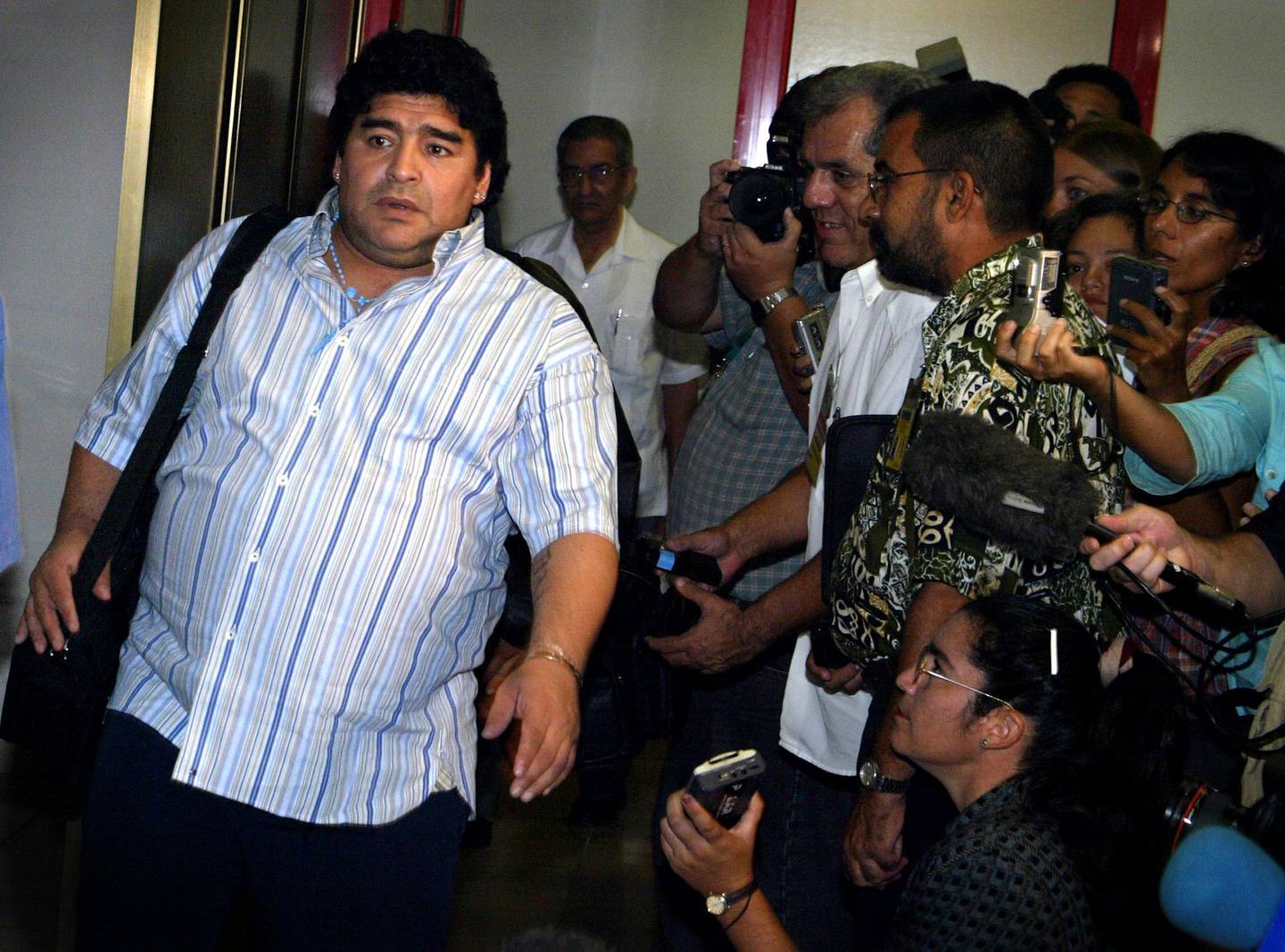 Argentine soccer legend Diego Maradona, left, arrives to Cuba to resume his drug rehabilitation in the outskirts of Buenos Aires, Monday, Sept. 20, 2004. Former soccer great Diego Maradona returned to Cuba on Monday to resume treatment for cocaine addiction after a relapse confined him to a psychiatric hospital in his native Argentina and sparked unsuccessful attempts by his family to keep him at home.  (AP Photos/Christobal Herrera)