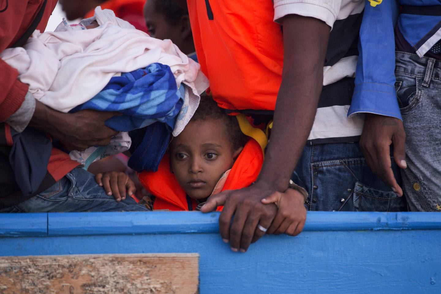 A boy looks on inside a crowded wooden boat carrying more than seven hundred migrants before being rescued, during a rescue operation in the Mediterranean sea, about 13 miles north of Sabratha,