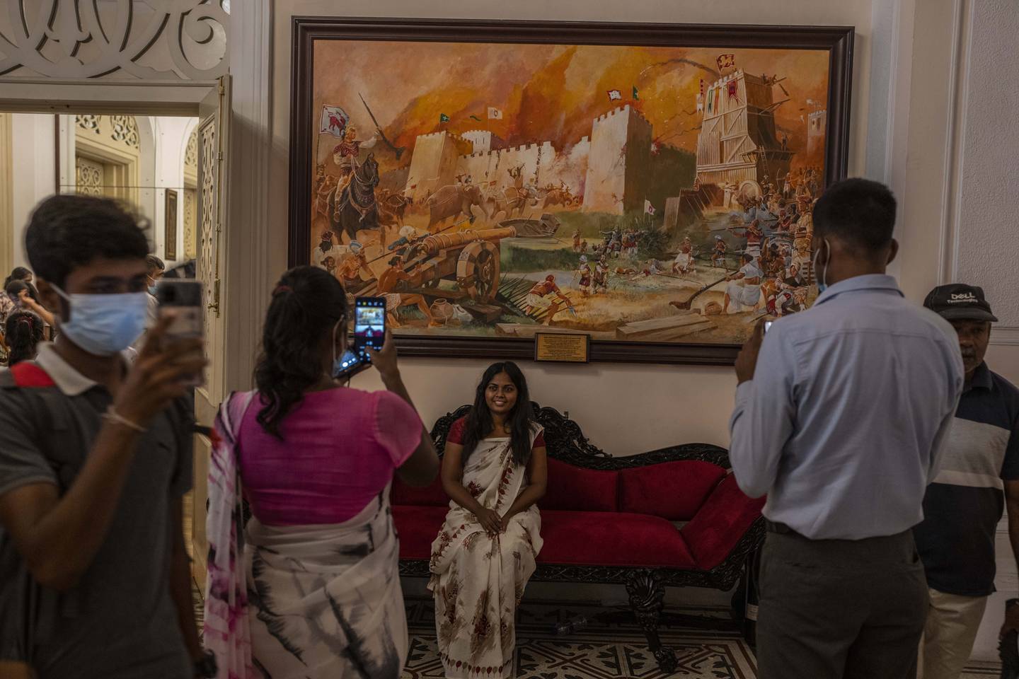 Folk tar selfier foran malerier i presidentpalasset i Colombo etter at palasset ble stormet og president Gotabaya Rajapaksa tvunget til å gå av. Foto: Rafiq Maqbool / AP / NTB