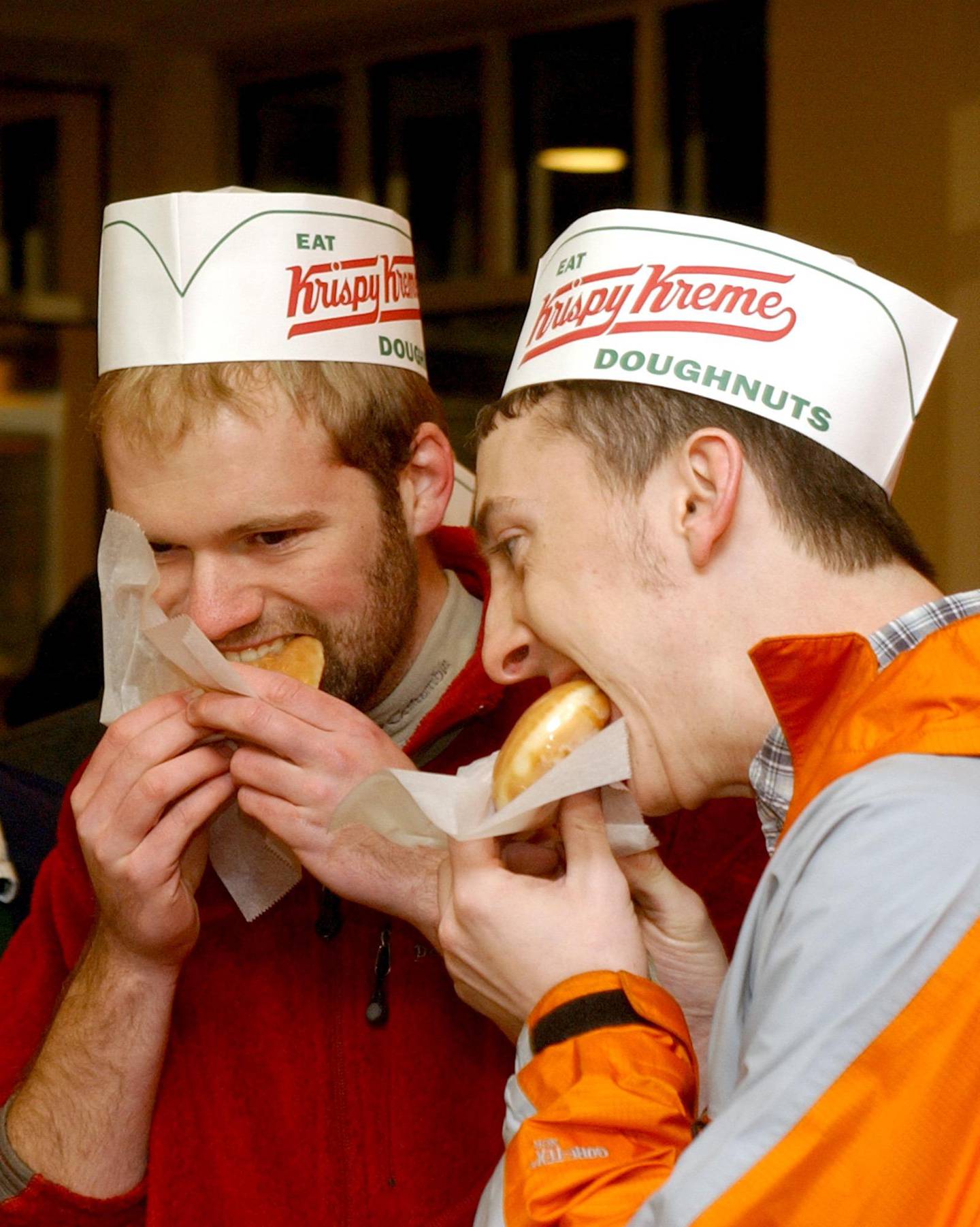 ** ELIMINATES THE REFERENCE TO THE FIRST STORE IN THE STATE **  Dustin Howell, left, and Daniel Geraldson enjoy fresh baked glazed doughnuts before heading to school during the grand opening of Krispy Kreme Doughnuts in Little Rock, Ark., Tuesday, Feb. 17, 2004.  The new Little Rock Krispy Kreme, which has the capacity to make over 2,000 doughnuts an hour, is the only one in the state. (AP Photo/Neemah Aaron)