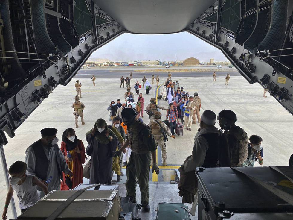 EN rekke land har sendt fly til Kabul for å evakuere egne statsborgere og lokalt ansatte som har arbeidet for dem. her går en gruppe afghanere om bord i et spansk transportfly. Foto: AP / NTB