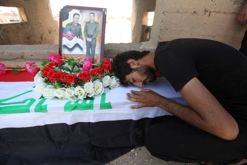 En mann sørger ved graven til en slektning på Wadi al-Salam-gravplassen. Mange er begravet i familiekrypter med plass til opp mot 50 døde.