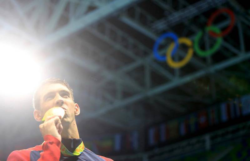 Tidenes olympier, Michael Phelps, kysser gullmedlajen han fikk for å bidra til at det amerikanske staffetlaget vant 200 meter stafett under Rio-OL.