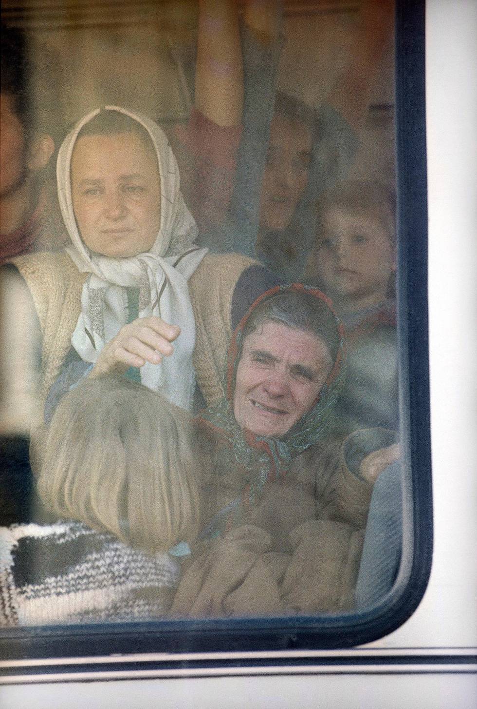 An elderly woman waves a goodbye to some relatives outside the window of a bus at the stadium, Wednesday, April 14, 1993 in Tuzla. The woman and other refugees from Sebrenica, who arrived with the United Nations convoy Tuesday night in Tuzla, are being distributed to nearby villages this morning. (AP Photo/Karsten Thielker)