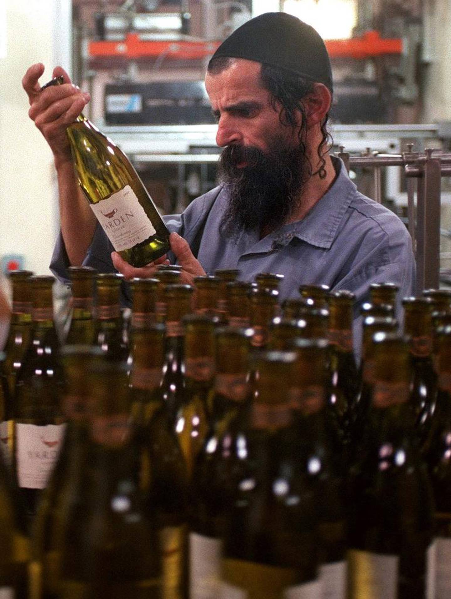 En arbeider på Golan Heights Winery sjekker en flaske av deres prisvinnende hvitvin. 