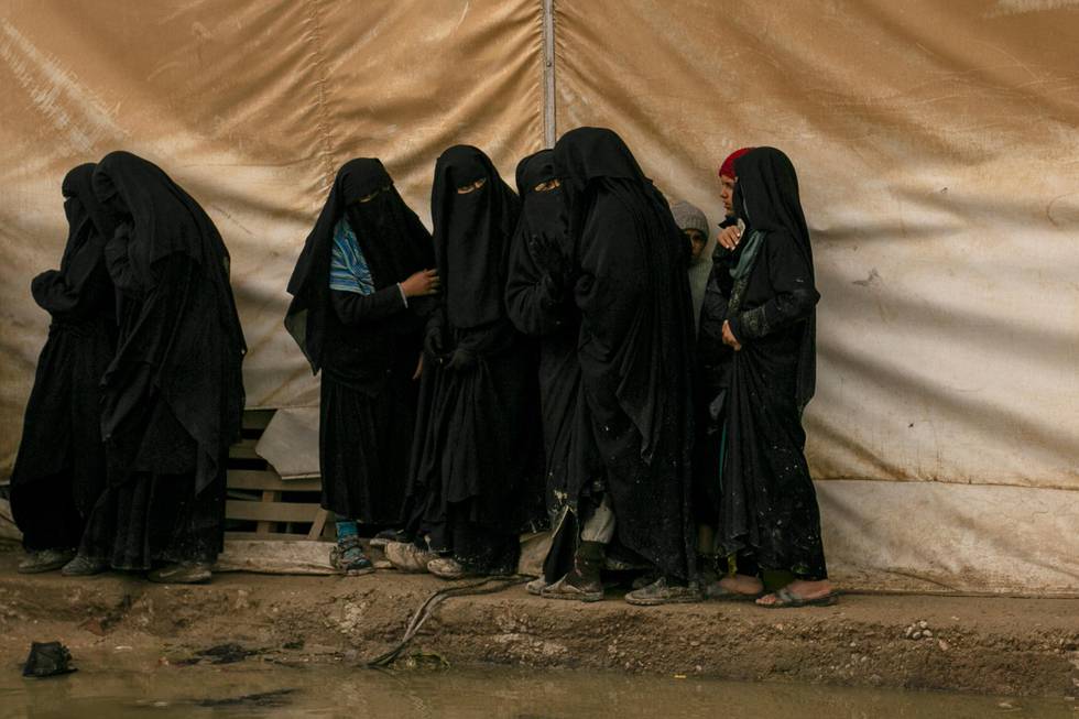 FILE - In this March 31, 2019, file, photo, women queue for aid supplies at al-Hol camp, home to Islamic State-affiliated families near Hasakeh, Syria. As Turkish troops invade northern Syria and the U.S. abandons its Kurdish allies, there are renewed fears of a prison break in the camp that could give new life to the extremist group. The Kurdish-led Syrian Democratic Forces are mobilizing to stop the Turkish invasion and say they may not be able to spare enough forces to secure al-Hol, home to tens of thousands of IS-linked women and their children.  (AP Photo/Maya Alleruzzo, File)