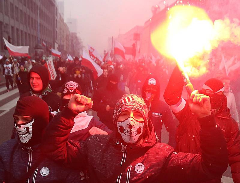 FILE - In this Friday, Nov. 11, 2016 file photo, nationalists, burning flares as they march in large numbers through the streets of Warsaw to mark Poland's Independence Day in Warsaw, Poland. Fascists and other far-right extremists are set to assemble in Warsaw for a march that has become one of the largest gatherings in Europe for increasingly emboldened white supremacists. (AP Photo/Czarek Sokolowski, File)