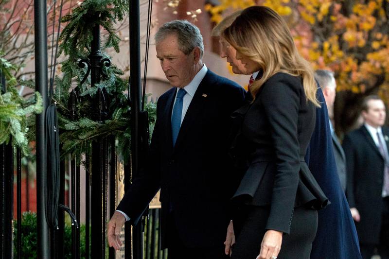 Former President George W. Bush leads President Donald Trump and first lady Melania Trump into Blair House across the street from the White House in Washington, Tuesday, Dec. 4, 2018. (AP Photo/Andrew Harnik)