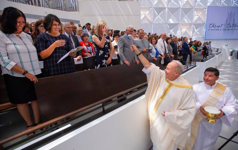 Rev. Christopher Smith, rector of Christ Cathedral, blesses the guests during the Solemn Mass of Dedication at Christ Cathedral, Wednesday, July 17, 2019, in Garden Grove, Calif. More than 2,000 guests attended the event that marked the opening of the building, now known as Christ Cathedral, the new home of the Diocese of Orange. The landmark was long known as Rev. Robert H. Schuller's Crystal Cathedral. (Mark Rightmire/The Orange County Register via AP)