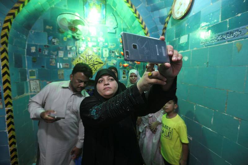 Helligdom: En muslimsk kvinne tar en «selfie» med mobilen inne i helligdommen tilegnet imam Mahdi.
