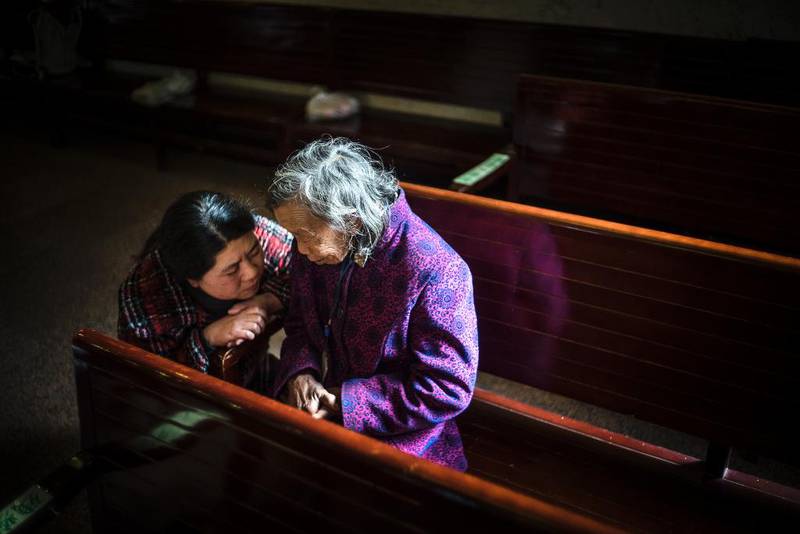 BER FOR KIRKEN: Pastor Lily Zheng (t.v.) i Trinity Church snakker med Lie Xie (82). Hun spør hva hun ber om.  – Jeg ber om at Jesus må være hodet i denne menigheten, svarer Xie.