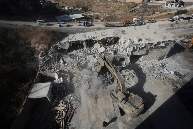 Israeli forces destroy a building in a Palestinian village of Sur Baher, east Jerusalem, Monday, July 22, 2019. Israeli work crews have begun demolishing dozens of Palestinian homes in an east Jerusalem neighborhood. Monday's demolitions cap a years-long legal battle over the buildings, which straddle the city and the occupied West Bank. (AP Photo/Mahmoud Illean)