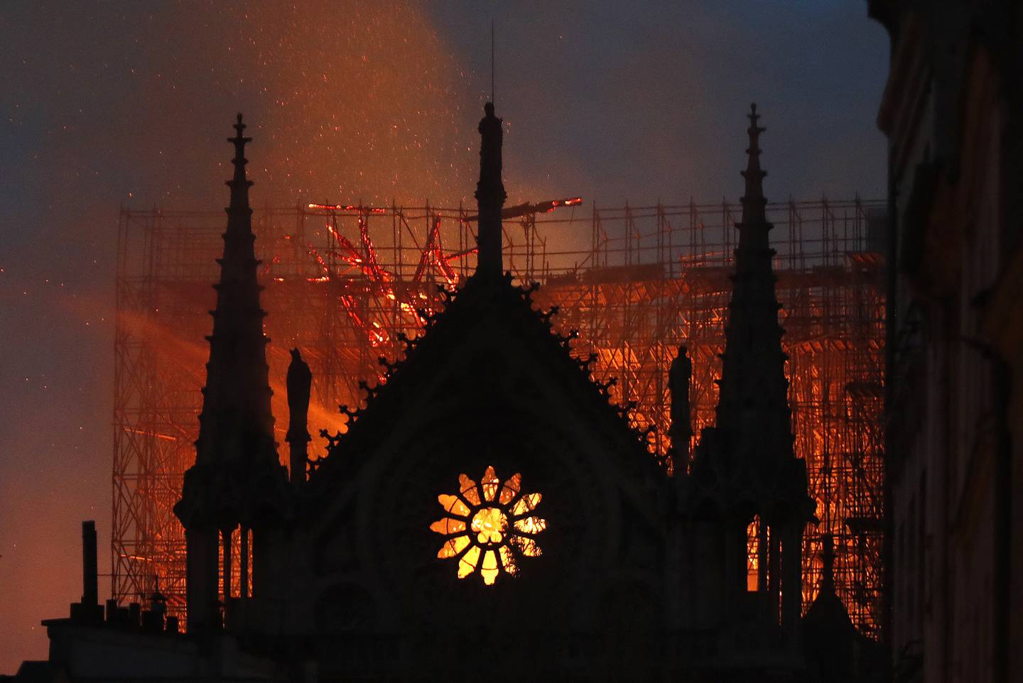 FILE - In this April 15, 2019, file photo, flames and smoke rise from Notre Dame Cathedral as it burns in Paris. The cathedral stands crippled, locked in a dangerous web of twisted metal scaffolding one year after a cataclysmic fire gutted its interior, toppled its famous spire and horrified the world. (AP Photo/Thibault Camus, File)