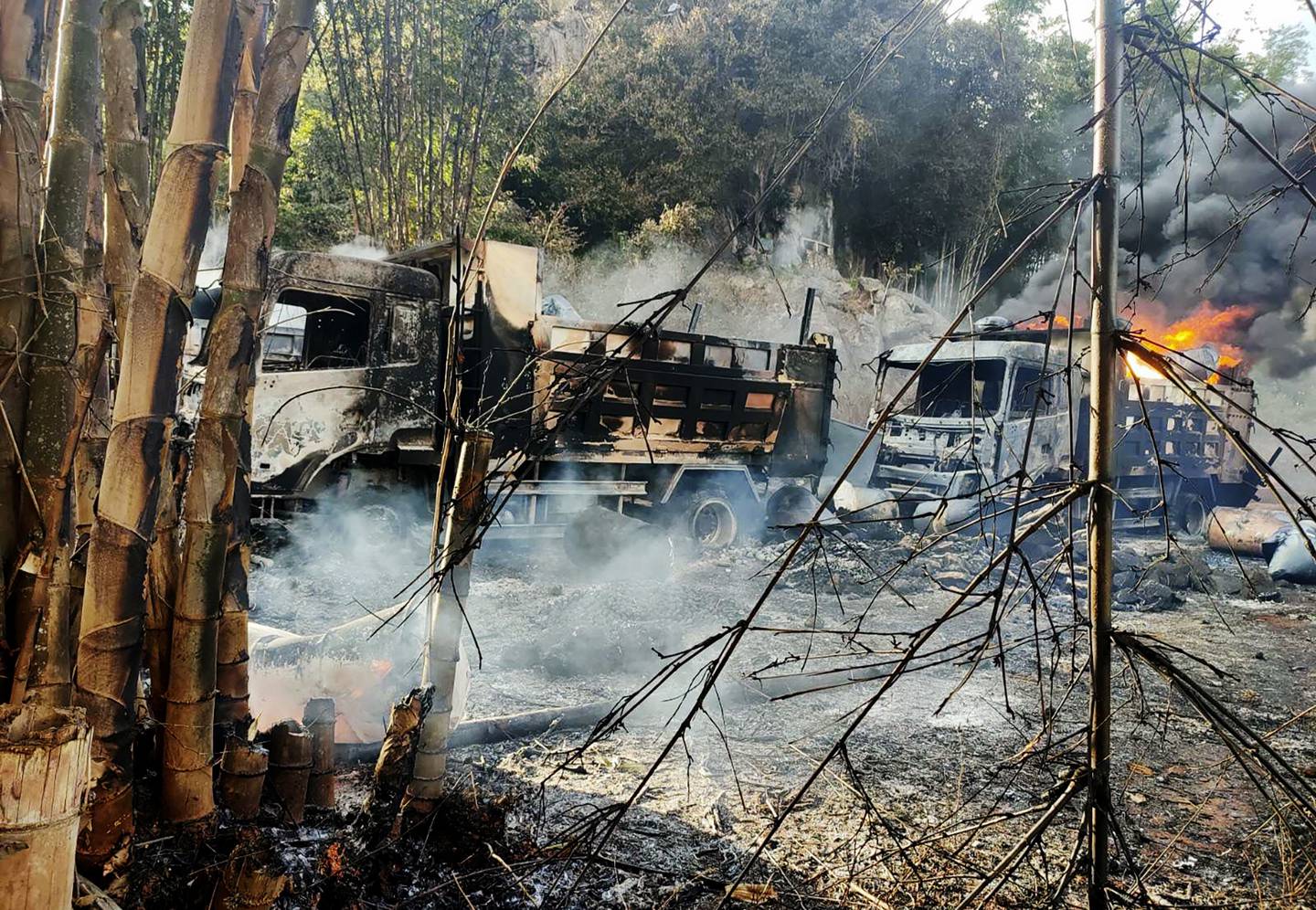 In this photo provided by the Karenni Nationalities Defense Force (KNDF), smokes and flames billow from vehicles in Hpruso township, Kayah state, Myanmar, Friday, Dec. 24, 2021. Myanmar government troops rounded up villagers, some believed to be women and children, fatally shot more than 30 and set the bodies on fire, a witness and other reports said Saturday. (KNDF via AP)