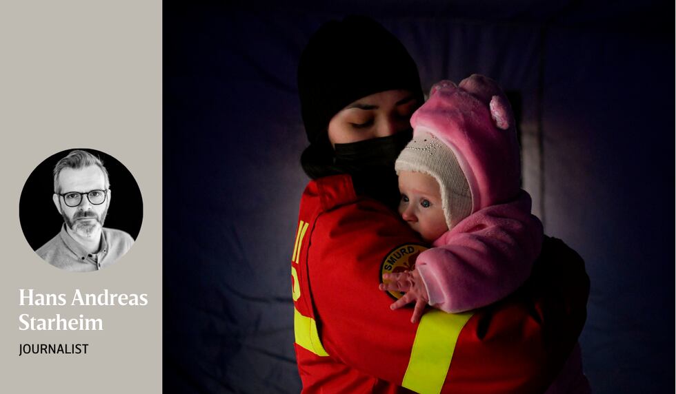 Ein lokal hjelpearbeidar trøystar eit gråtande barn som nettopp har kome over grensa frå Ukraina til Romania saman med familien sin, kort tid etter at krigen braut ut.