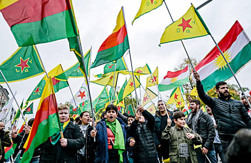 People with flags of the Kurdish YPG protest against the Turkish invasion in Kurdish territories in northern Syria in Hamburg, Germany, Saturday, Oct. 12, 2019. (Axel Heimken/dpa via AP)