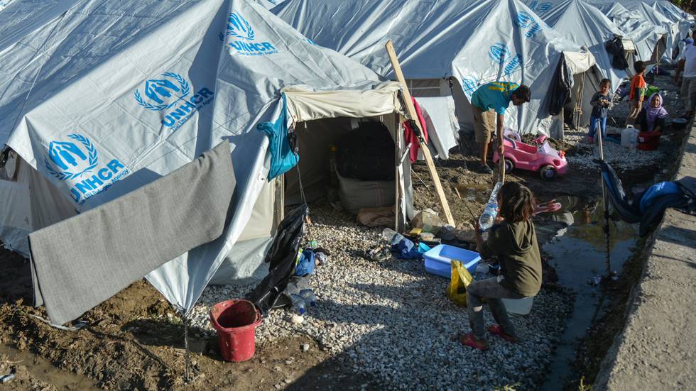Migrants clean their tents after a rainstorm at the Kara Tepe refugee camp, on the northeastern Aegean island of Lesbos, Greece, Wednesday, Oct. 14, 2020. Around 7,600 refugees and migrants have settled at the new tent city after successive fires on Sept. 9, devastated the Moria refugee camp, making thousands of inhabitants homeless during a COVD-19 lockdown.  (AP Photo/Panagiotis Balaskas)