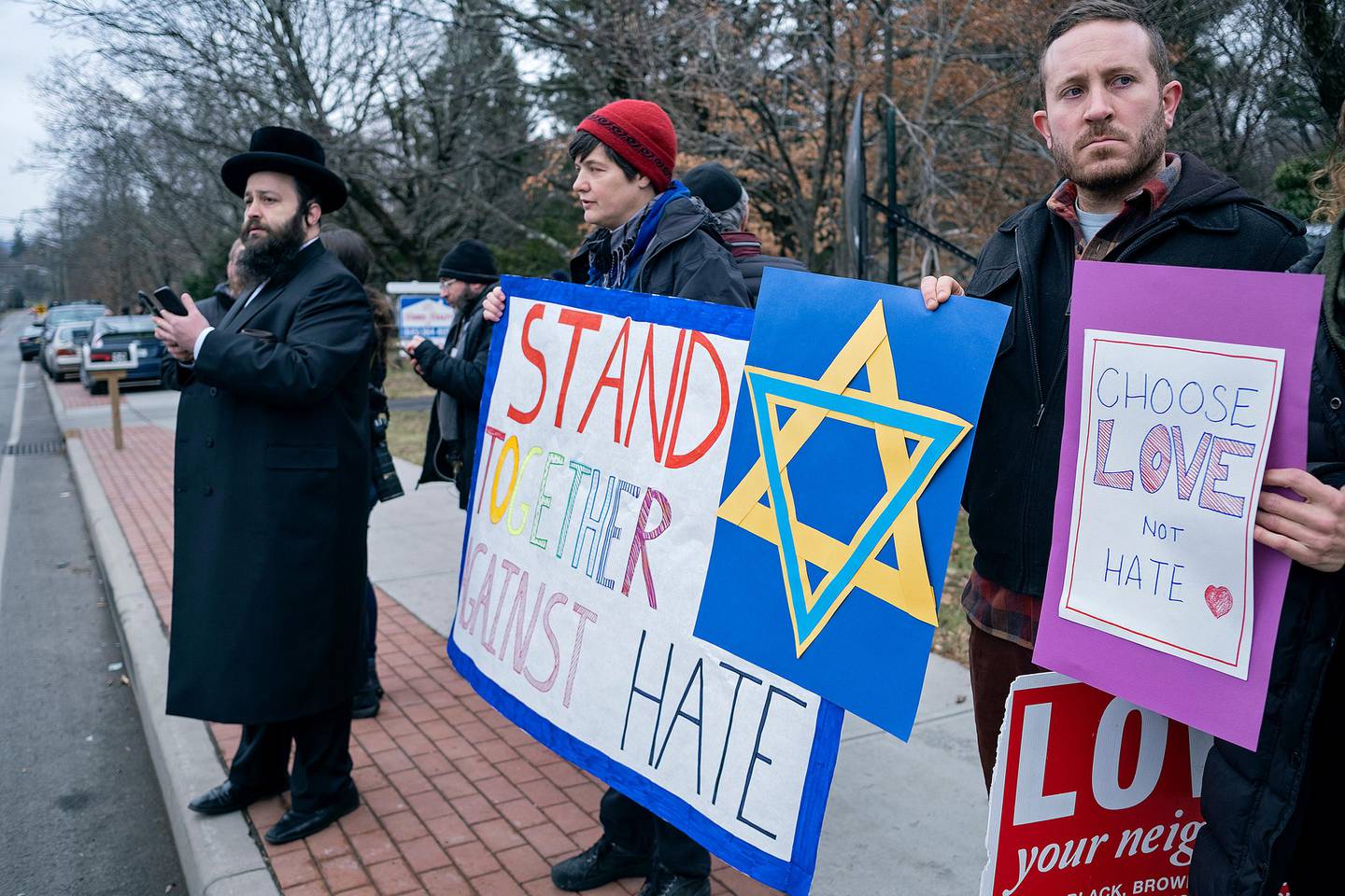 Neighbors gather to show their support of the community near a rabbi's residence in Monsey, N.Y., Sunday, Dec. 29, 2019, following a stabbing Saturday night during a Hanukkah celebration. (AP Photo/Craig Ruttle)