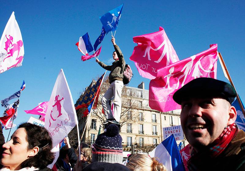 Demonstrators holding flags to protest the French Socialist government's  family and education policies in Paris, Sunday, Feb. 2, 2014. Tens of thousands of protesters march during a rally through Paris  and Lyon on Sunday to defend their vision of the traditional family. Flags reads, "Manif pour tous" (Protest for Everyone). (AP Photo/Thibault Camus)