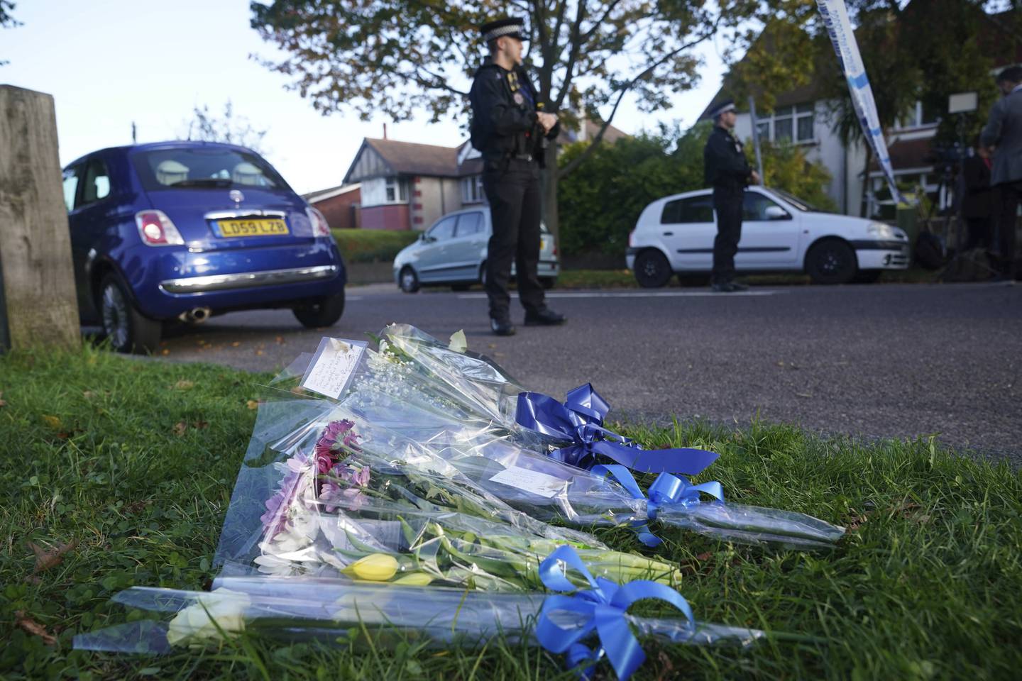 Folk la ned blomster nær stedet der politikeren David Amess ble knivstukket og drept i Essex fredag. Foto; AP / NTB