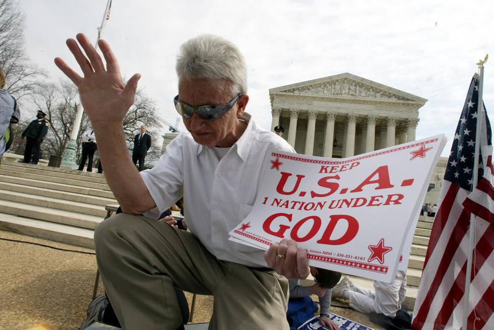 I amerikanernes troskapsed til nasjonen og flagget sier amerikanerne «One nation under God». Her ber en amerikaner utenfor USAs høyesterett i 2004 hvor en høring om troskapseden fant sted.