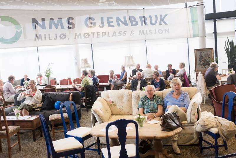 Deltakere på generalforsamlingen slapper av i kafeen der man kan kjøpe både brukte møbler og stekte lapper.