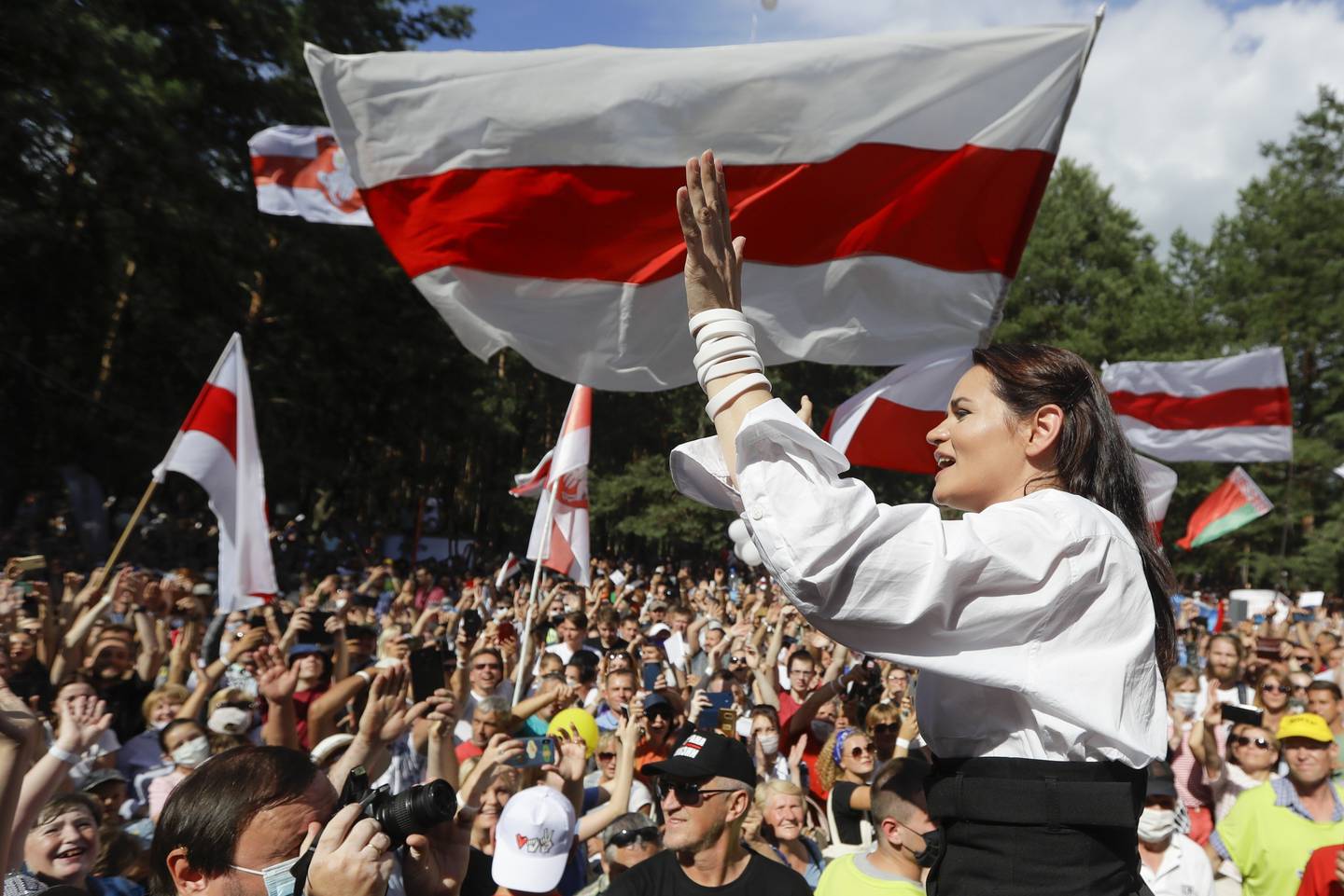 FILE - Sviatlana Tsikhanouskaya, candidate for the presidential elections greets people waving old Belarus flags during a meeting to show her support in Brest, 326 km (203,7 miles) southwest of Minsk, Belarus on Sunday, Aug. 2, 2020. Belarusian opposition leader Sviatlana Tsikhanouskaya says she received an anonymous note alleging that her imprisoned husband, also an opposition figure, died behind bars. Siarhei Tsikhanouski was arrested in 2020 after announcing plans to run against Belarus' authoritarian leader, Alexander Lukashenko, in presidential elections that year. Tsikhanouskaya ran in his stead after the arrest. (AP Photo, File)