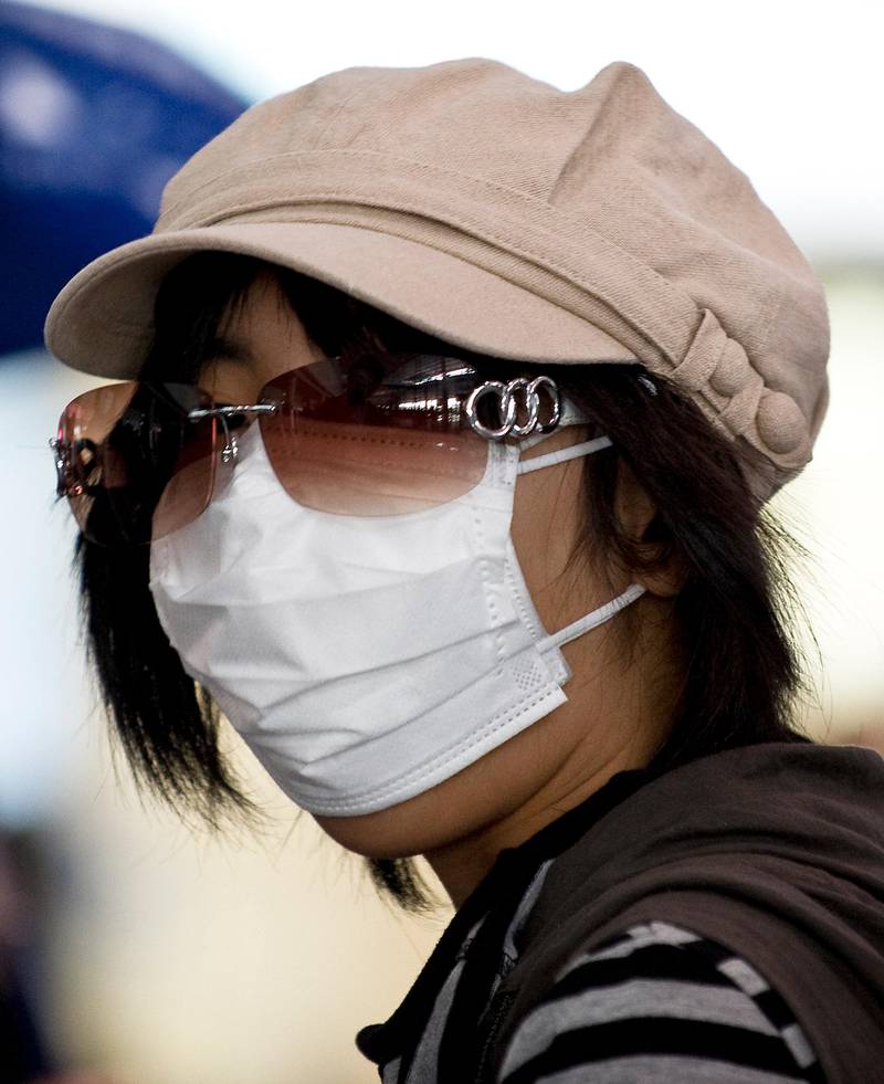 A tourist wearing a mask as a precaution against the swine flu, waits at the arrival hall of Beijing Capital International Airport in Beijing, China, Sunday, May 3, 2009.  China suspended all direct flights from Mexico and sealed 305 people inside a Hong Kong hotel where an infected Mexican tourist stayed. Health workers in white bodysuits patrolled the lobby where the 25-year-old Mexican stayed before he became Asia's first confirmed case late Friday. (AP Photo/Andy Wong)