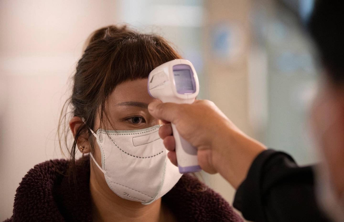 Health officials check tourists' temperatures on arrival in hopes of containing the spread of the COVID-19 virus at the Suvarnabhumi Airport in Bangkok, Thailand, Wednesday, March 4, 2020. (AP Photo/Sakchai Lalit)