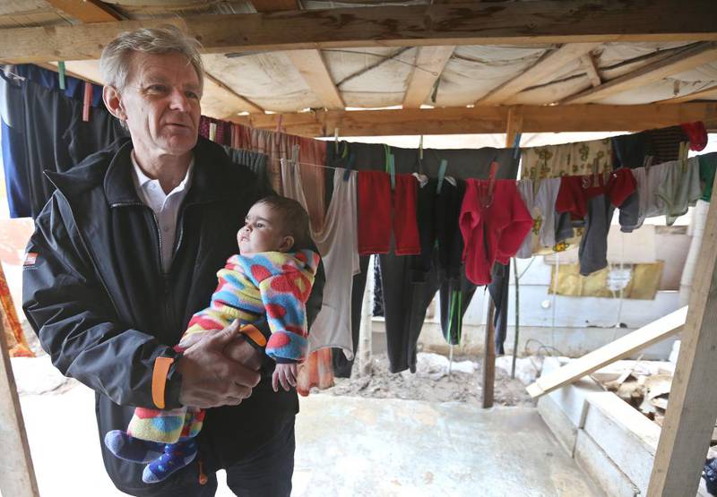Jan Egeland, generalsekretær for Flyktninghjelpen, holder et syrisk barn under et besøk i en flyktningleir i byen Marej i Beka-dalen i Libanon i februar i år.