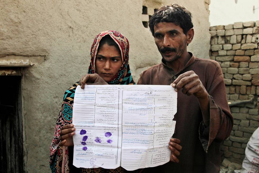 CORRECTS NAME TO RAMZAN NOT RAMAZAN - In this Tuesday, Dec. 20, 2016 photo, Mohammad Ramzan shows his marriage contract with his young bride Saima in Jampur, Pakistan. Saima was given as a bride to the older man by her father so he could marry the groom?Äôs sister, a practice of exchanging girls that is entrenched in conservative regions of Pakistan. It even has its own name in Urdu: Watta Satta, ?Äúgive and take.?Äù A mix of interests _ family obligations, desire for sons, a wish to hand off a girl to a husband _ can lead to a young teen in an a marriage she never sought.(AP Photo/K.M. Chaudhry)