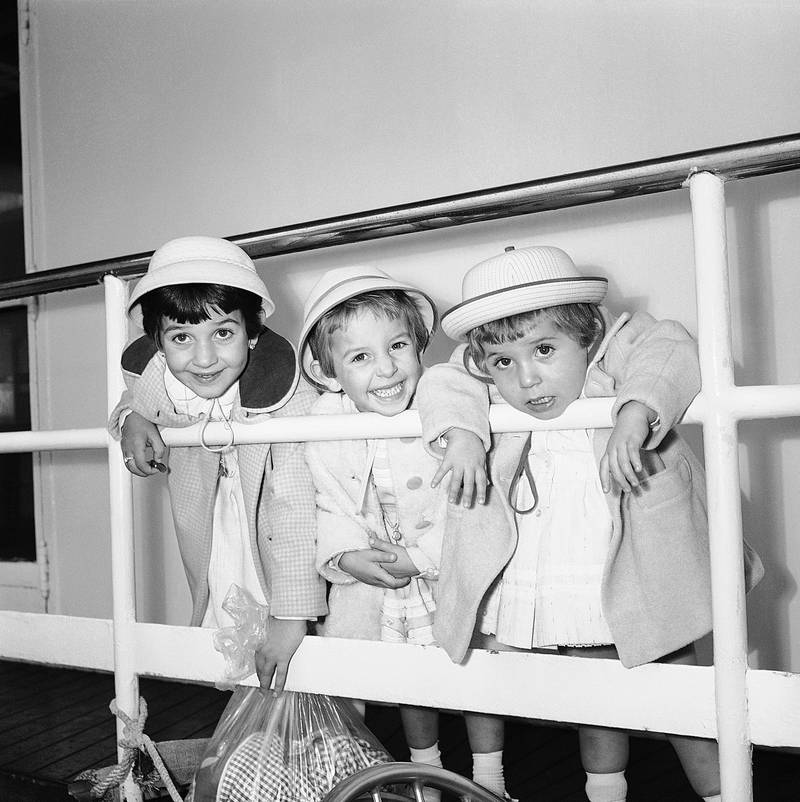 Three sisters from Bari, Italy appear to have mixed emotions as they arrive in New York aboard the liner Cristoforo Colombo  November 3, 1961.   The girls, from left, Rosa Maria,6,  Lucia, 4, and Vincenza, 2, arrived with the mother Emilia Coletta.  They will join father Donato, in Corona, New York.  (AP Photo)