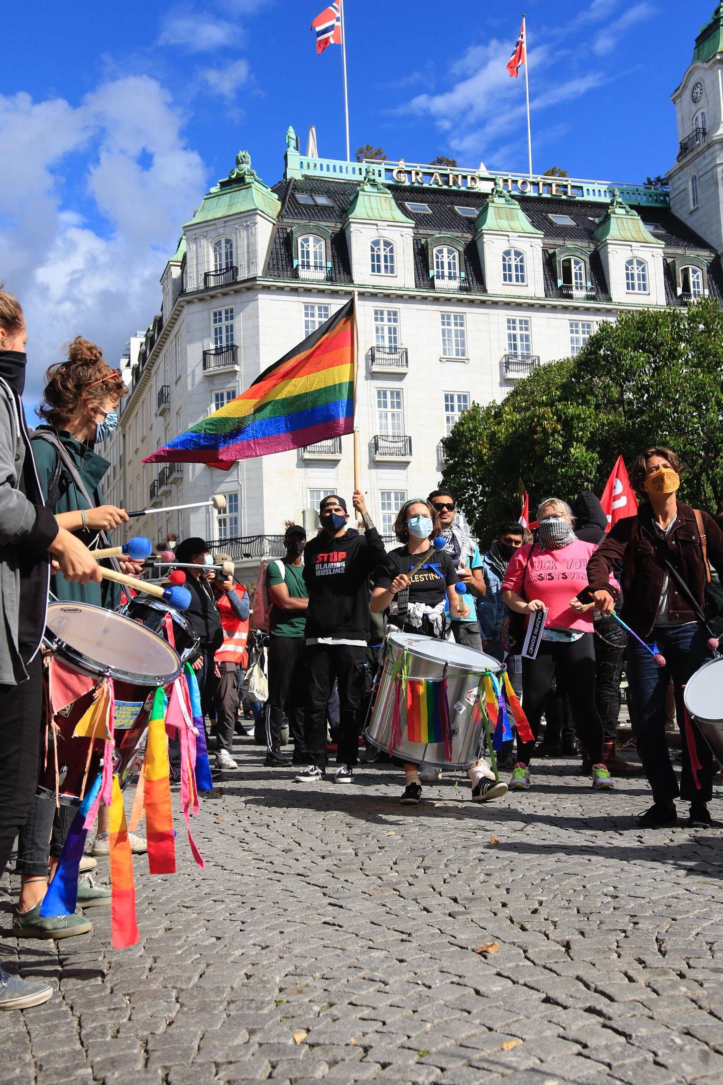 Demonstranter med regnbueflagg og store trommer har møtt opp for å overdøve Sian.