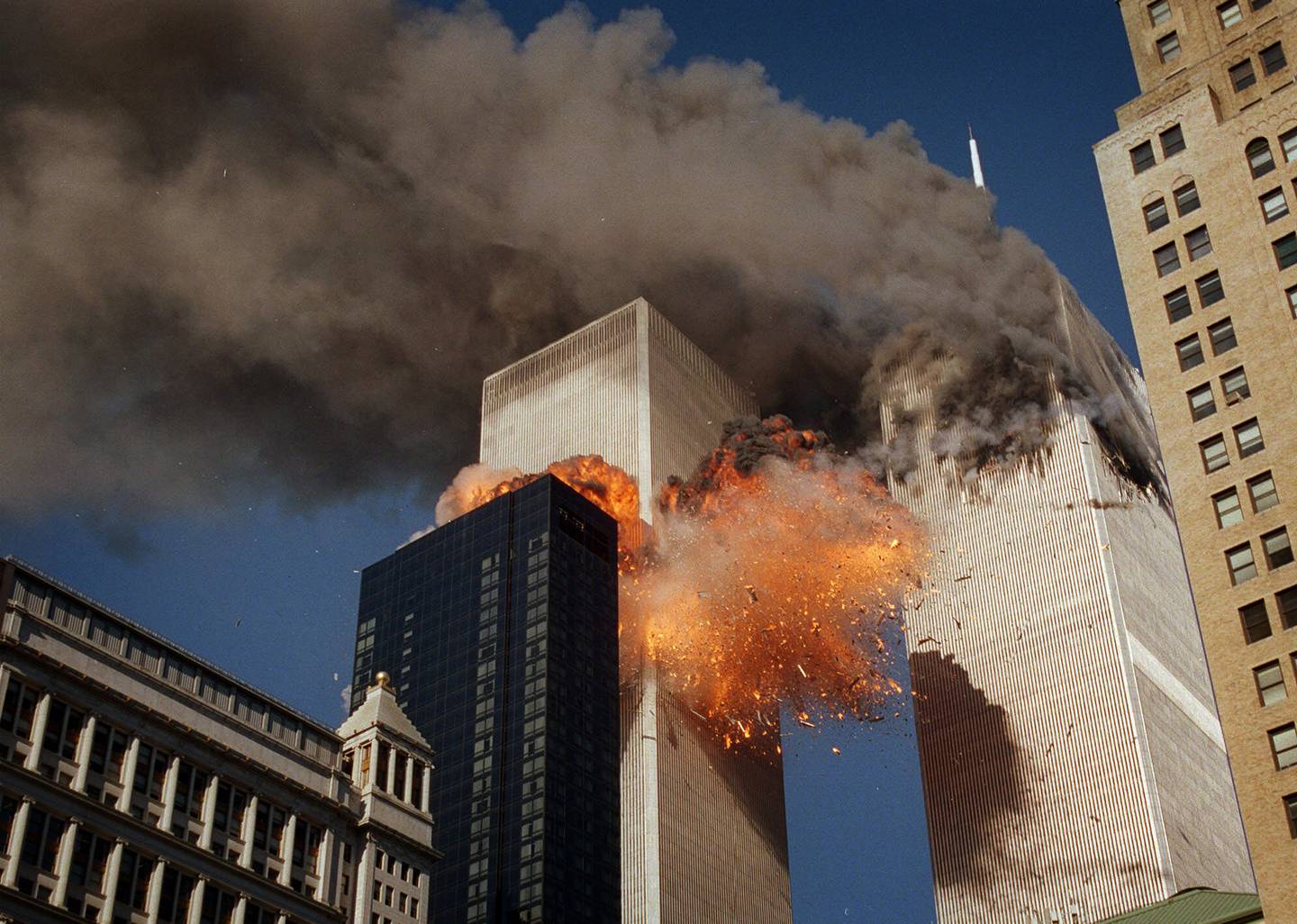 Smoke billows from one of the towers of the World Trade Center as flames and debris explode from the second tower, Tuesday, Sept. 11, 2001. (AP Photo/Chao Soi Cheong)