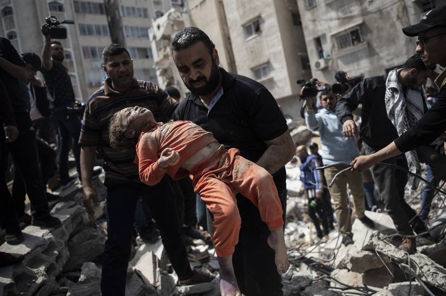 Over 2.100 palestinske barn er drept i israelske angrep de siste 20 årene. Her bæres et barn ut av ruinene av en boligblokk i Gaza by som ble bombet sist søndag. Foto: AP / NTB