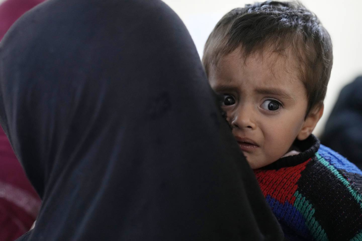 An Afghan woman holds her sick son at the malnutrition ward of the Indira Gandhi Children's Hospital, in Kabul, Afghanistan, Thursday, Feb. 24, 2022.