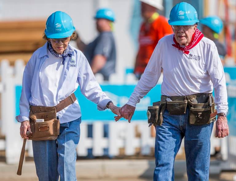 Former President Jimmy Carter holds hands with his wife, former first lady Rosalynn Carter, as they work with other volunteers on site during the first day of the weeklong Jimmy & Rosalynn Carter Work Project, their 35th work project with Habitat for Humanity, on Monday, Aug. 27, 2018, in Mishawaka, Ind. (Robert Franklin/South Bend Tribune via AP)