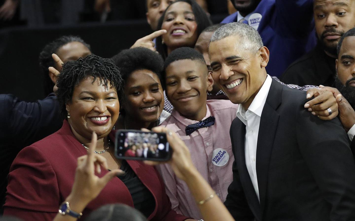 Former President Barack Obama and Democratic candidate for Georgia Governor Stacey Abrams pose for a photograph with two unidentified family members after a campaign rally at Morehouse College Friday, Nov. 2, 2018, in Atlanta. (AP Photo/John Bazemore)