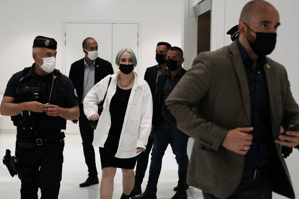 The teenager identifying herself online as Mila, center right, leaves the courtroom Monday, June 21, 2021 in Paris. Thirteen people went on trial in Paris accused of cyberbullying or death threats against the teenage girl who posted comments online critical of Islam. (AP Photo/Thibault Camus)