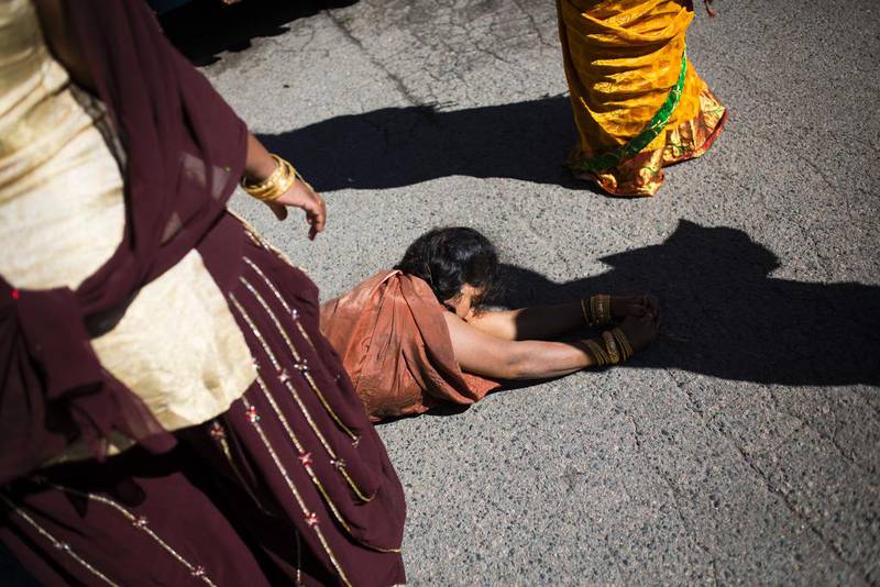 En kvinne ruller etter opptoget for å oppleve smerte i sinn bønn til guden.