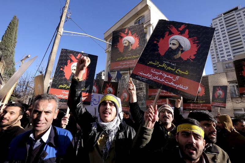 Iranske demonstranter utenfor den saudiarabiske ambassaden i Teheran holder opp bilder av den henrettede sjiamuslimske rettslærde Sjeik Nimr al-Nimr. Henrettelsen i Saudi-Arabia lørdag har forverret isfronten mellom landene.
