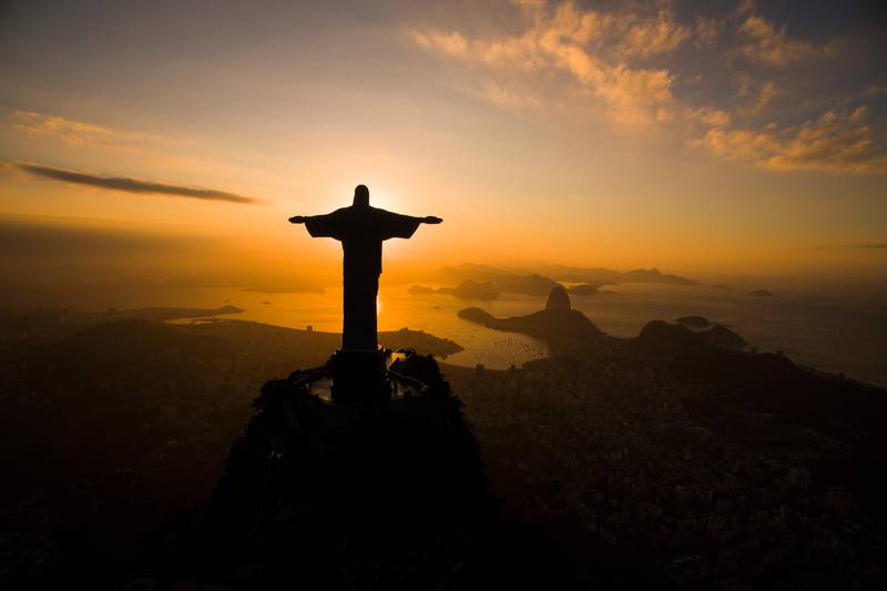 The sun rises behind the Christ the Redeemer statue, above the Guanabara bay in Rio de Janeiro, Brazil, Tuesday, July 19, 2016. With the Olympics set to start on Aug. 5, the games and the city have been overshadowed by security threats, violence, the Zika virus and a national political corruption scandal. (AP Photo/Felipe Dana)