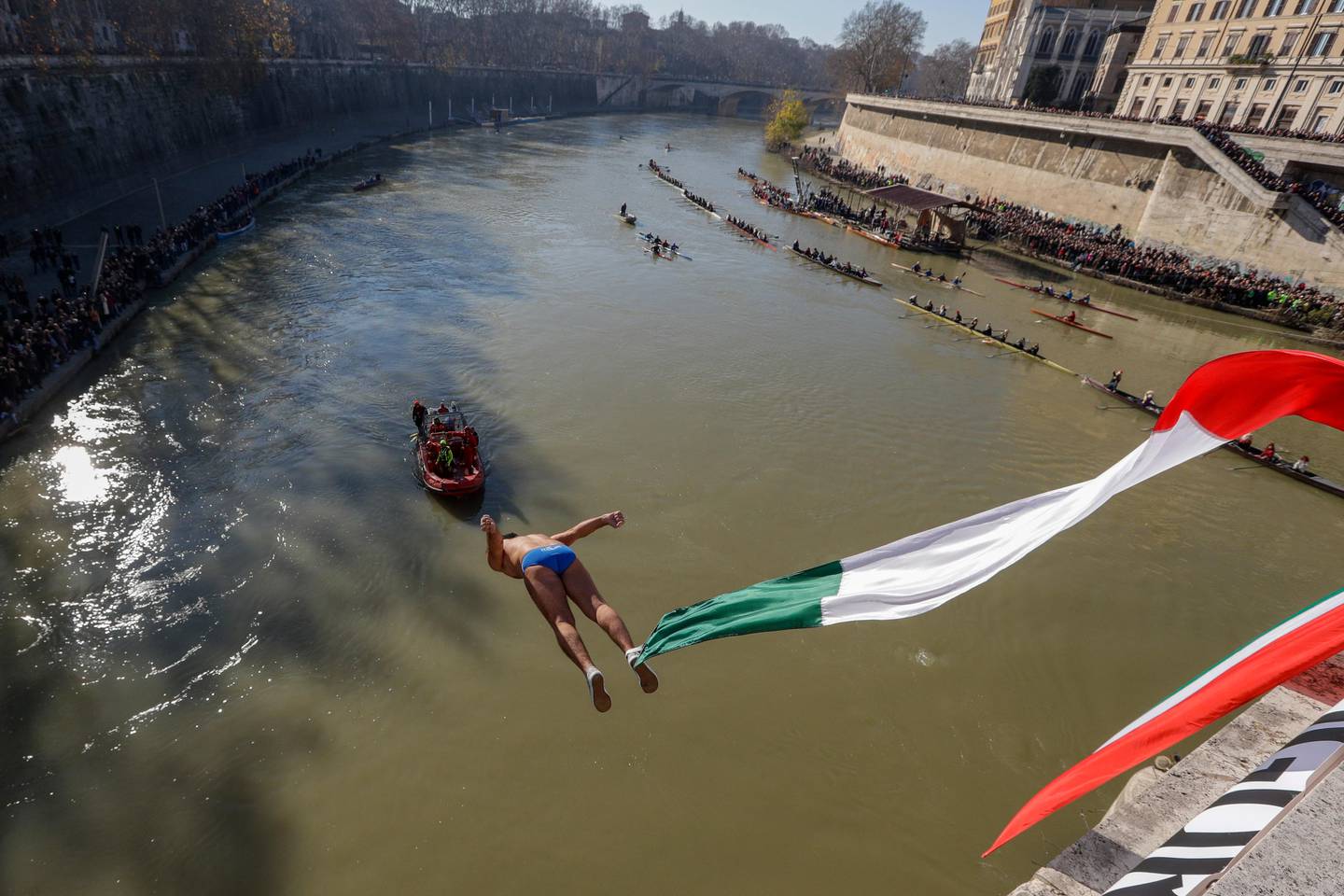 Valter Schirra dives into the Tiber river from the 18 meters (59 feet) high Cavour Bridge in Rome, Wednesday, Jan. 1, 2020. (AP Photo/Andrew Medichini)