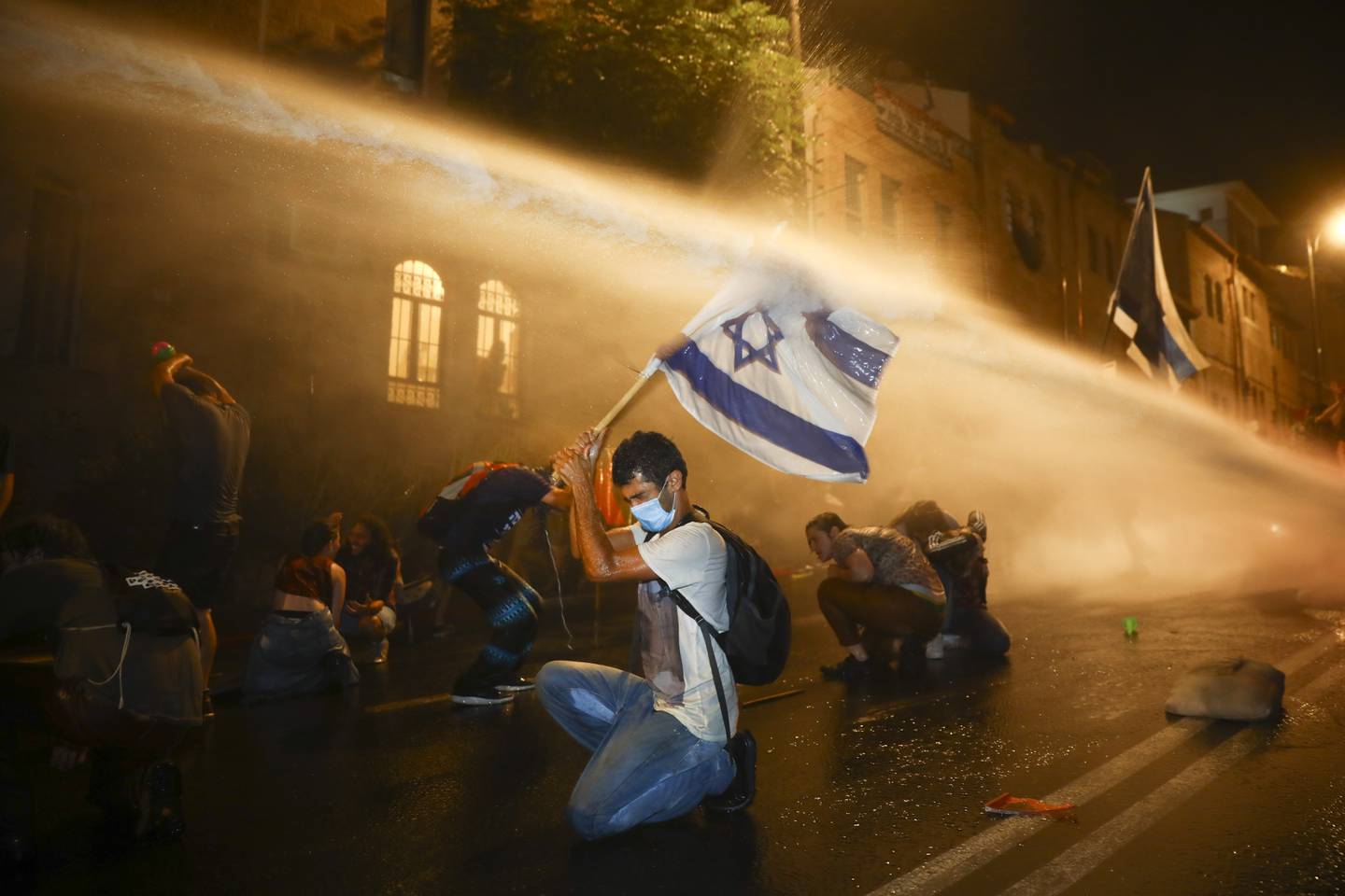 Israeli police uses water canon to disperse people during a protest against Israeli Prime Minister Benjamin Netanyahu In Jerusalem Saturday, July 18, 2020. Protesters demanded that the embattled Israeli leader to resign as he faces a trial on corruption charges and grapples with a deepening coronavirus crisis. (AP Photo/Oded Balilty)