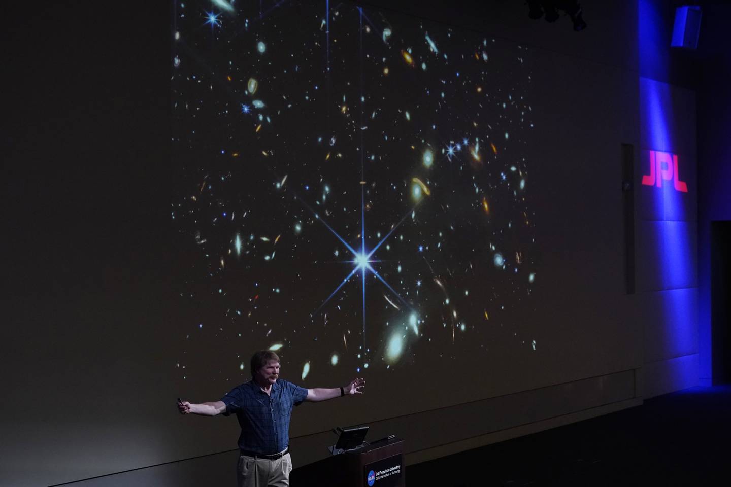 Nasa-forsker Michael Ressler under presentasjonen tirsdag. Bildet bak ham viser det dypeste og skarpeste infrarøde bildet som er tatt av det tidlige universet. Foto: Marcio Jose Sanchez / AP / NTB