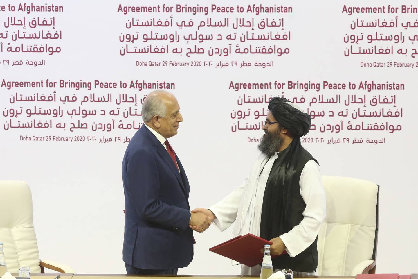 Mulla Baradar var sentral da avtalen om amerikansk tilbaketrekning fra Afghanistan ble inngått med tidligere president Donald Trumps administrasjon. Her er han avbildet sammen med USAs utsending Zalmay Khalilzade i Doha, Qatar i februar 2020.