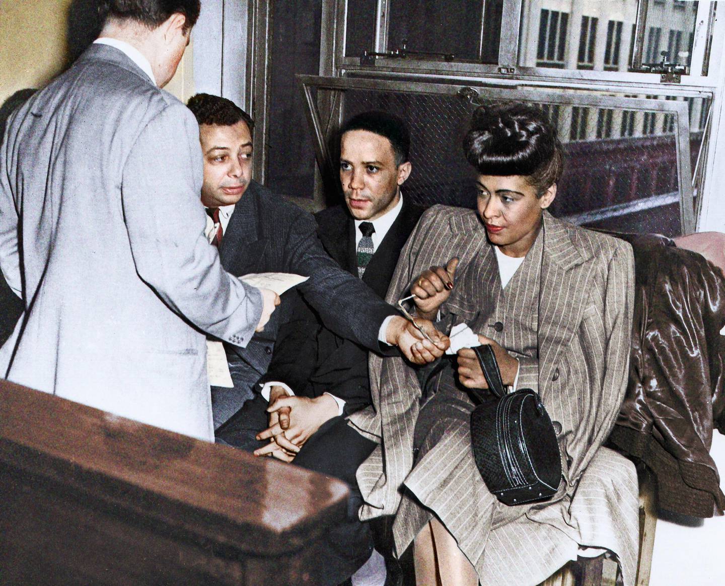 PHILADELPHIA - MAY 20:  Jazz singer Billie Holiday (R) is read the charge for heroin possession at the U.S. Commissioners Office, seated next to her are her pianist Bobby Tucker (C) and road manager James Asendio (R) on May, 20, 1947 in Philadelphia, Pennsylvania.   (Photo by Michael Ochs Archives/Getty Images)