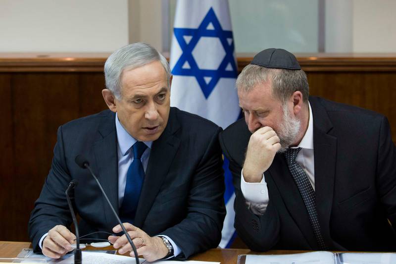 FILE - In this Nov. 8, 2015 file photo, Israel's Prime Minister Benjamin Netanyahu, left, speaks with then Cabinet Secretary Avichai Mandelblit during the weekly cabinet meeting in Jerusalem. The attorney general Avichai Mandelblit's decision on whether to indict Netanyahu on a series of corruption allegations is expected to be delivered Thursday, Feb. 28, 2019. Mandelblit is expected to announce his decision after more than two years of intense investigations and deliberations. (Abir Sultan/Pool Photo via AP, File)