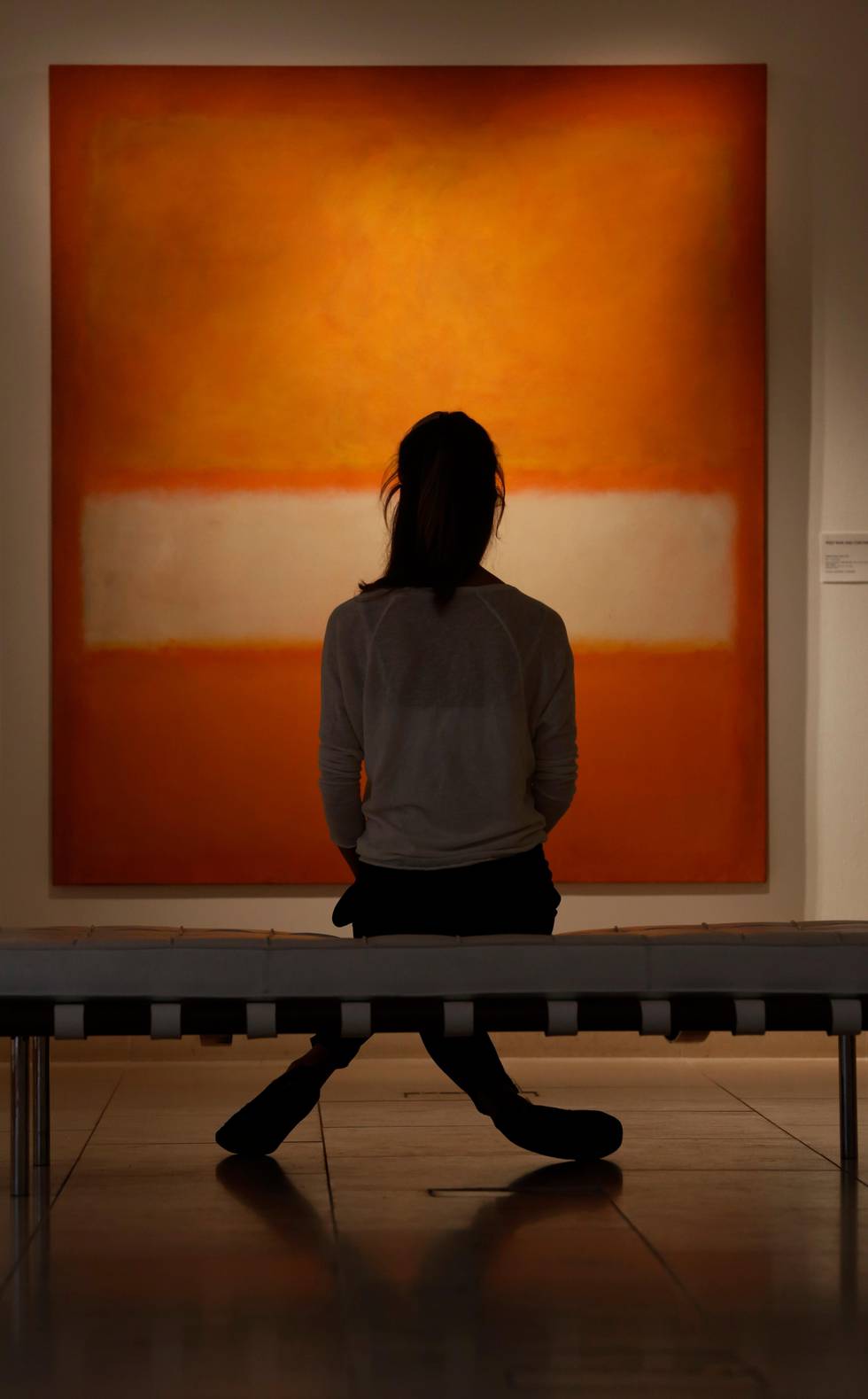 An auction house worker poses for photographers in front of an untitled oil on canvas 1957 painting by Mark Rothko in central London, Monday, Oct. 14, 2013. The artwork will be offered in auction at Christie's New York 'Evening Sale of Post-War and Contemporary Art' on Nov. 12, 2013. It is estimated to fetch some US$ 25-35 million (euro 18,4- 25,8 million). (AP Photo/Lefteris Pitarakis)