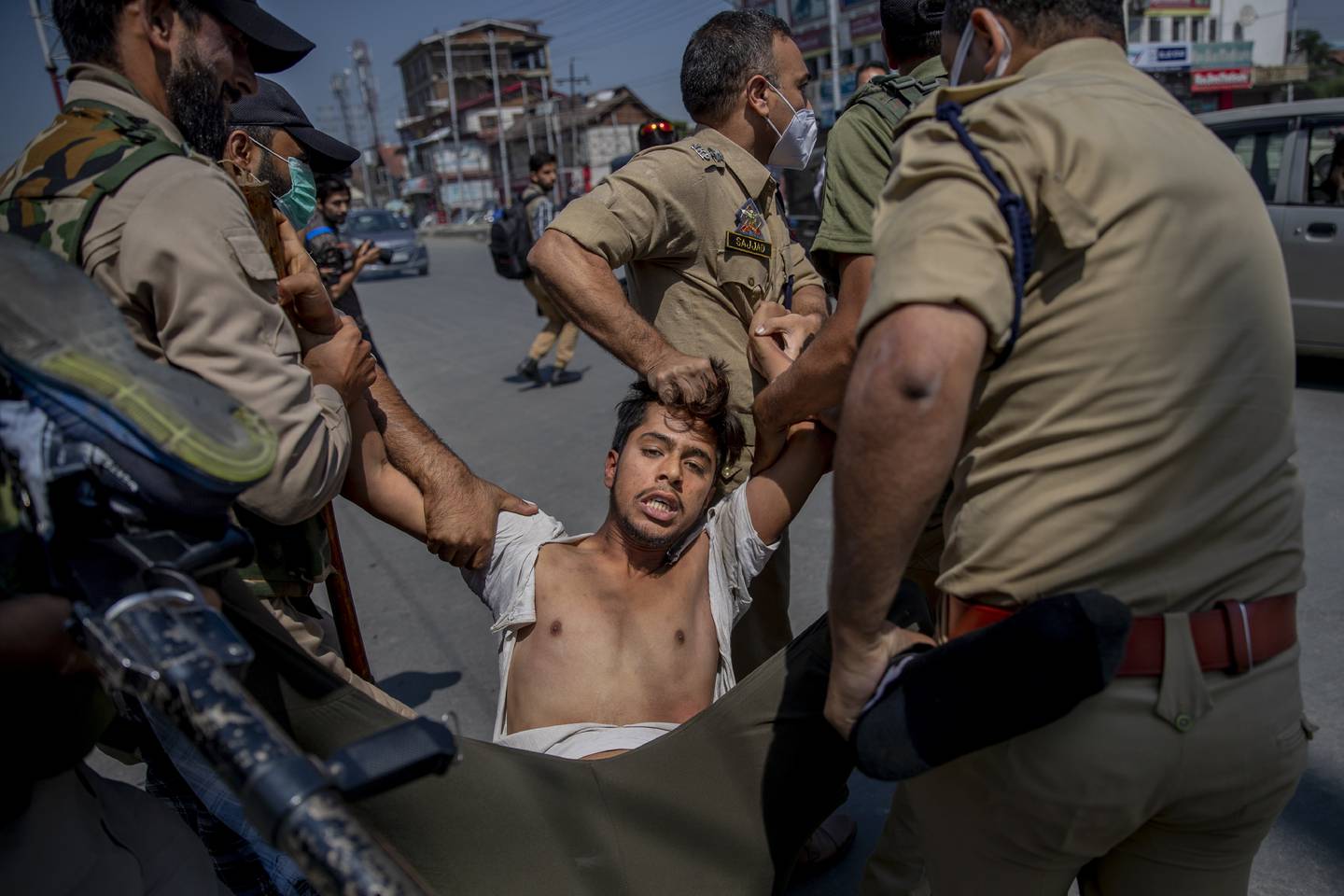 Indian policemen detain a Kashmiri Shiite Muslim for participating in a religious procession in central Srinagar, Indian controlled Kashmir, Tuesday, Aug. 17, 2021. Police in Indian-controlled Kashmir on Tuesday fired tear gas and warning shots to disperse hundreds of Shiite Muslims, while detaining dozens who attempted to participate in processions marking the Muslim month of Muharram. (AP Photo/Dar Yasin)